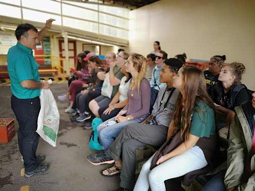 A group of students listening to a teacher.